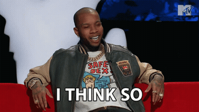 A Man Wearing A Safe Sex T-Shirt Sits On A Red Couch GIF