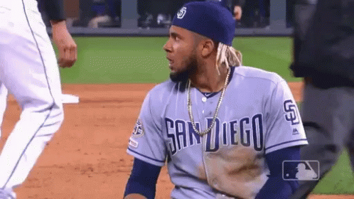 A Man Wearing A San Diego Jersey Is Sitting On The Baseball Field GIF