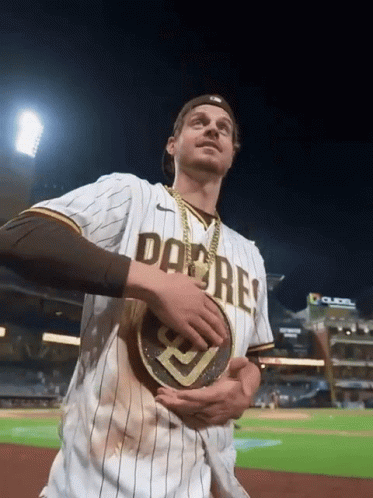 A Man Wearing A San Diego Padres Jersey Holds A Gold Coin GIF