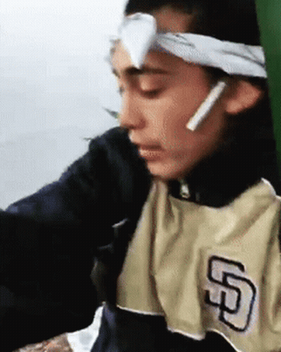 A Man Wearing A San Diego Padres Shirt Has A Bandage On His Forehead . GIF