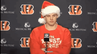 A Man Wearing A Santa Hat And A Red Sweater That Says " The Lusty Krab " GIF