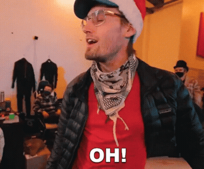 A Man Wearing A Santa Hat And Glasses Is Standing In A Room And Saying Oh ! GIF