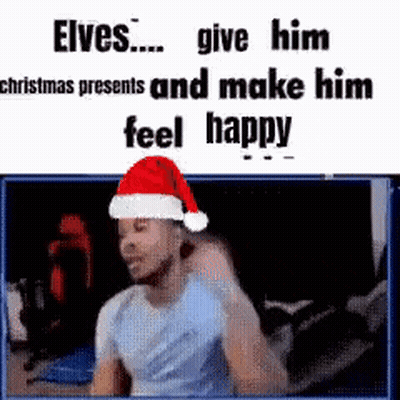 A Man Wearing A Santa Hat Is Sitting In Front Of A Screen . GIF