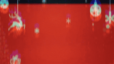 A Man Wearing A Santa Hat Is Surrounded By Christmas Decorations On A Red Background GIF