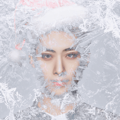 A Man Wearing A Santa Hat Is Surrounded By Snowflakes GIF