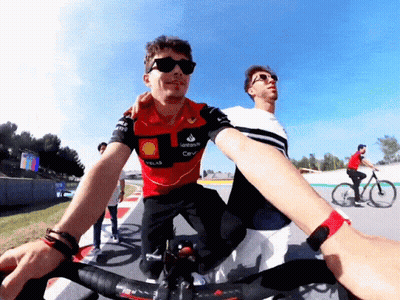 A Man Wearing A Santander Shirt Rides A Bike GIF