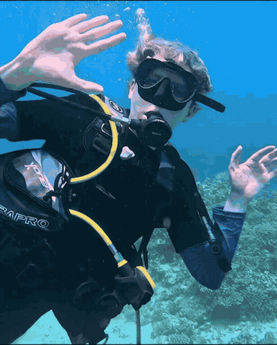 A Man Wearing A Scubapro Scuba Diving Suit Is Swimming In The Ocean GIF