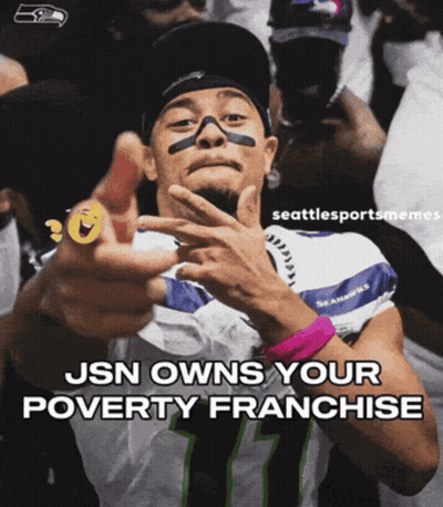 A Man Wearing A Seahawks Jersey Is Pointing At The Camera GIF
