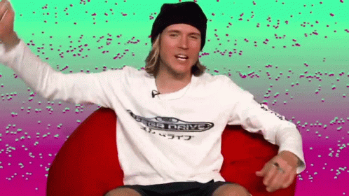 A Man Wearing A Sega Drive Shirt Is Sitting On A Bean Bag Chair . GIF