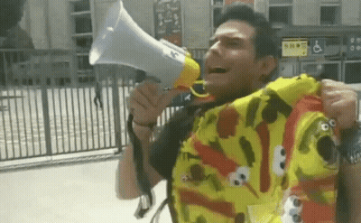 A Man Wearing A Sesame Street Shirt Holds A Megaphone GIF