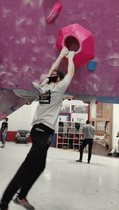 A Man Wearing A Shirt That Says ' Abercrombie & Fitch ' On It Climbs A Wall GIF