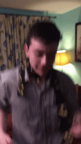 A Man Wearing A Shirt That Says ' Abercrombie & Fitch ' On It Is Standing In A Room GIF