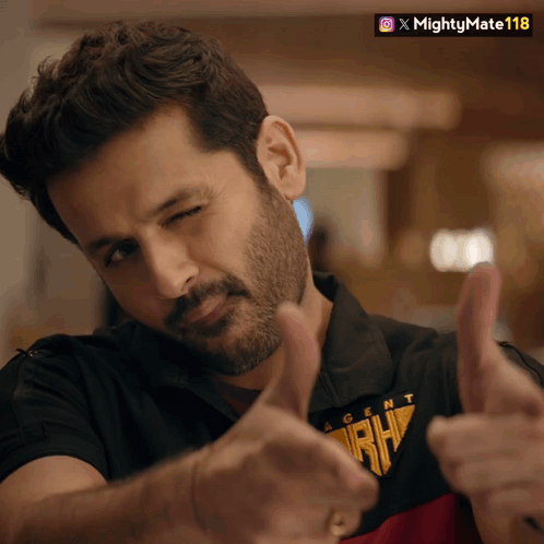 A Man Wearing A Shirt That Says Agent Rh Is Giving Two Thumbs Up GIF