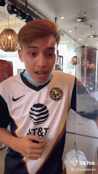 A Man Wearing A Shirt That Says At & T Is Standing In A Restaurant GIF
