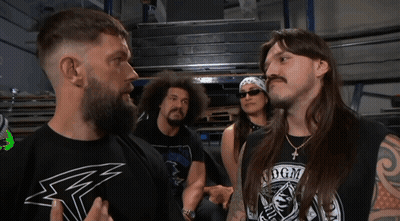 A Man Wearing A Shirt That Says Dgm Stands In Front Of Two Other Men GIF
