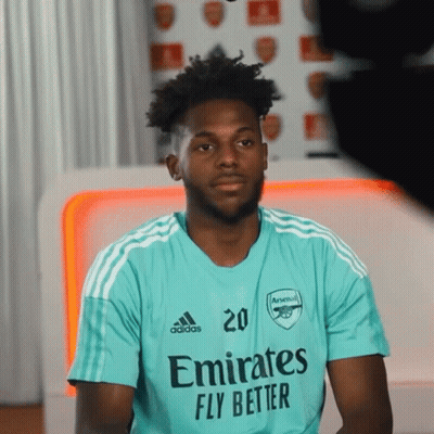 A Man Wearing A Shirt That Says Emirates Fly Better On It GIF