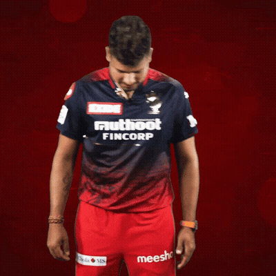 A Man Wearing A Shirt That Says Exide Muthoot Fincorp Stands In Front Of A Red Background GIF