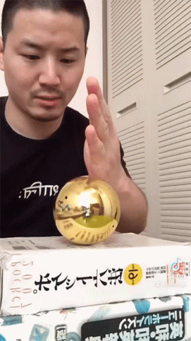 A Man Wearing A Shirt That Says ' Faith ' On It Holds A Gold Ball GIF