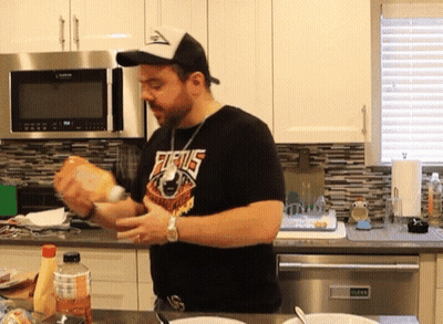 A Man Wearing A Shirt That Says Furius Is Preparing Food In A Kitchen GIF
