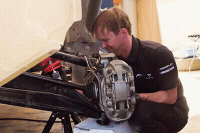 A Man Wearing A Shirt That Says Gmc On It Is Working On A Car GIF