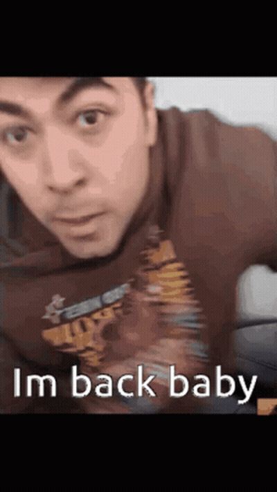 A Man Wearing A Shirt That Says ' I 'M Back Baby ' GIF