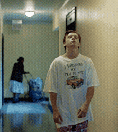 A Man Wearing A Shirt That Says " I Survived My Trip To Nyc " GIF