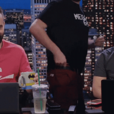 A Man Wearing A Shirt That Says Mega 69 Stands In Front Of A Laptop GIF
