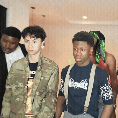 A Man Wearing A Shirt That Says Misfits Is Standing Next To A Man In A Camouflage Jacket GIF