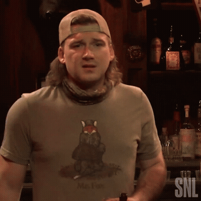 A Man Wearing A Shirt That Says Mr. Fox Is Standing In Front Of A Bar GIF