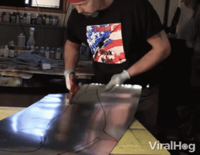 A Man Wearing A Shirt That Says ' Punk ' On It Is Working On A Piece Of Metal GIF