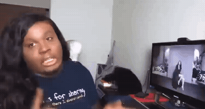A Man Wearing A Shirt That Says S For Sharing Is Sitting In Front Of A Computer Screen . GIF