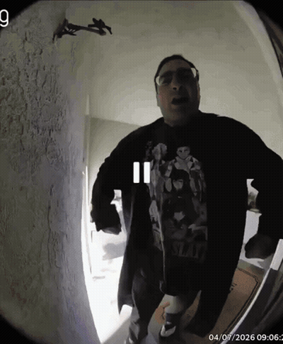 A Man Wearing A Shirt That Says Slash Stands In Front Of A Door GIF