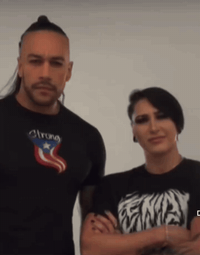 A Man Wearing A Shirt That Says Strong Stands Next To A Woman Wearing A Shirt That Says Ena GIF