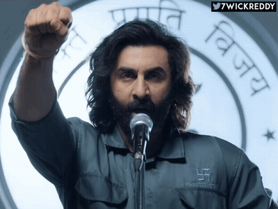 A Man Wearing A Shirt That Says Swastik Trust GIF