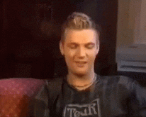 A Man Wearing A Shirt That Says Tour Is Sitting On A Couch GIF