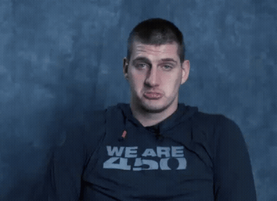 A Man Wearing A Shirt That Says We Are Zoo Is Making A Funny Face With His Hands . GIF