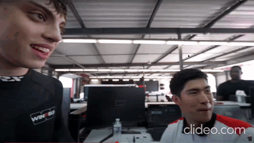 A Man Wearing A Shirt That Says Winner On It Talks To Another Man GIF