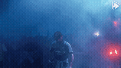 A Man Wearing A Shirt That Says X + X Is Walking Through Smoke GIF