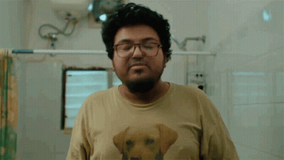 A Man Wearing A Shirt With A Dog On It Is Washing His Hands GIF