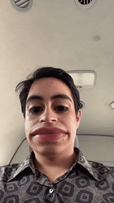 A Man Wearing A Shirt With A Geometric Pattern Makes A Funny Face GIF