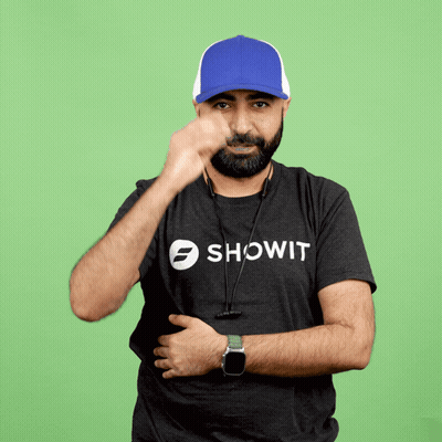 A Man Wearing A Showit Shirt Covers His Face With A Blue Hat GIF