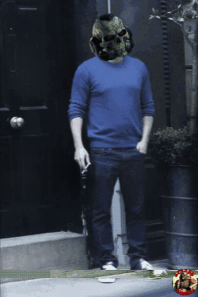 A Man Wearing A Skull Helmet Is Standing In Front Of A Door GIF
