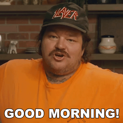 A Man Wearing A Slayer Hat And An Orange Shirt Says Good Morning GIF