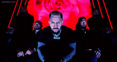 A Man Wearing A Solo Necklace Stands In Front Of A Group Of Men GIF