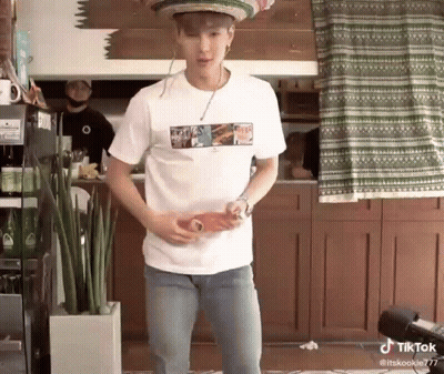A Man Wearing A Sombrero And A White Shirt Is Holding A Bottle Of Soda . GIF