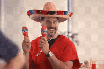A Man Wearing A Sombrero And Holding Maracas In His Hands GIF