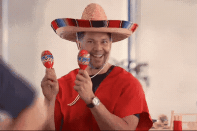 A Man Wearing A Sombrero And Holding Maracas In His Hands GIF