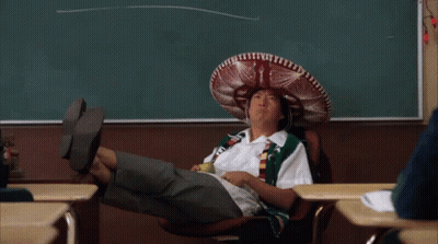 A Man Wearing A Sombrero Sits In A Chair In Front Of A Chalkboard GIF