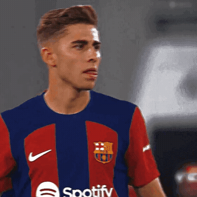 A Man Wearing A Spotify Shirt Looks At Something GIF