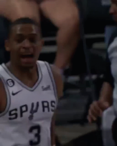 A Man Wearing A Spurs Jersey Is Talking To A Referee GIF
